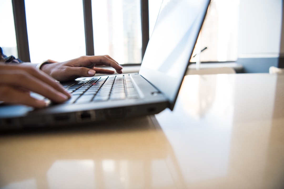 person-using-black-laptop-on-brown-table-sjo-vsskn9s
